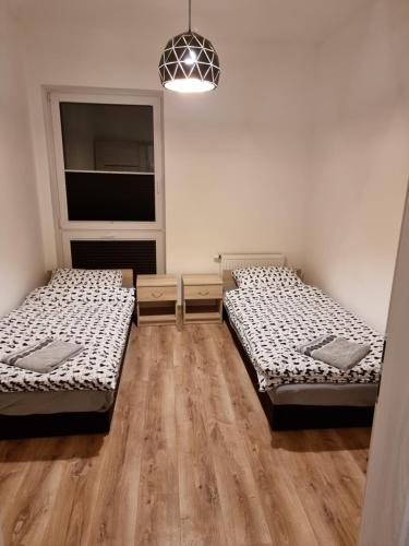 a room with two beds and a window at Apartament Oporowska 22A in Kutno