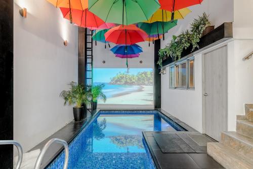 una casa con una piscina con ombrelloni sopra di essa di Viktory Boutique Hotel a Medellín
