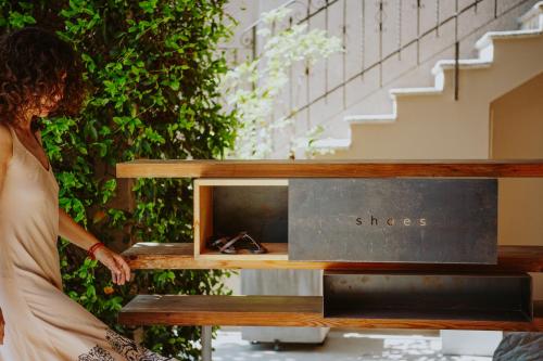 a woman standing next to a wooden bench with a box at B&B Panorama Cinque in Salò