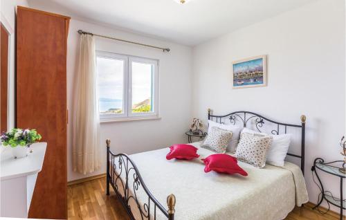 Un dormitorio con una cama con almohadas rojas. en 4 Bedroom Stunning Home In Tucepi, en Tučepi