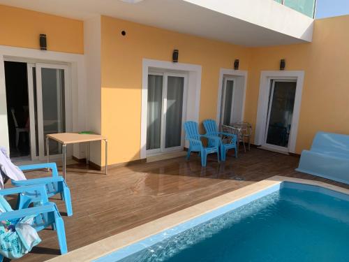 a room with a swimming pool and chairs and a table at ORANGE guest house in Sagres