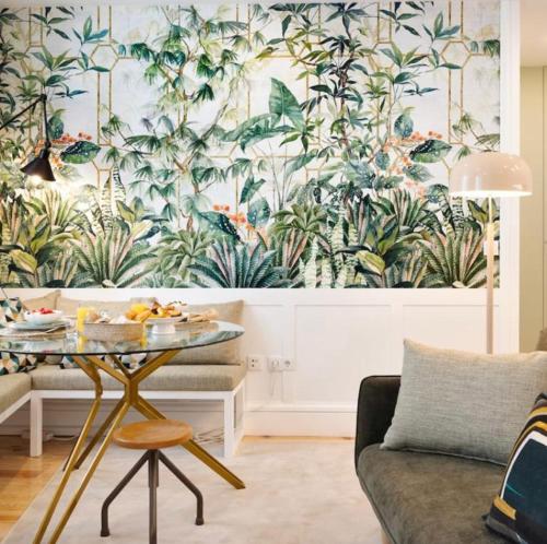 a living room with a table and a mural of plants at Away to Enjoy Apartment - hapiness has a place in Porto