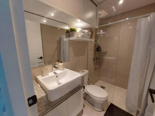 een badkamer met een wastafel, een toilet en een douche bij The Florence at McKinley Hill in Manilla