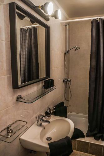 a bathroom with a sink and a mirror and a shower at Anna Vendégház Eger in Eger