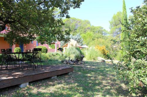 a garden with chairs and a table in the grass at Villa COLIBRI in Lorgues