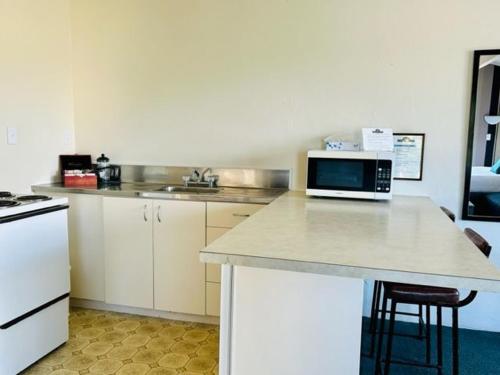 uma cozinha com um balcão e um micro-ondas em Parkside Motel and Apartments em New Plymouth