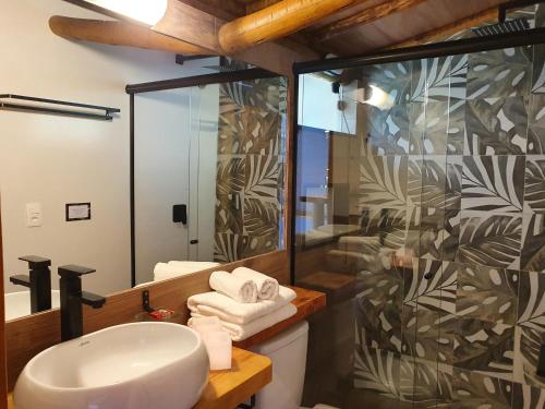 a bathroom with a sink and a shower at Pousada Tekoá Indiana in Cachoeiras de Macacu