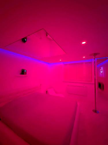 Camera con luci rosa e vasca da bagno di Sweet Love Room a Talange