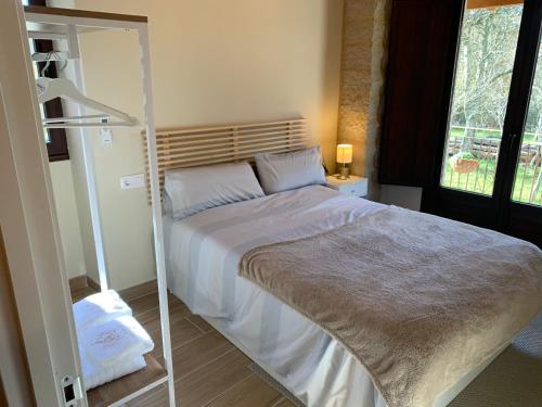 a bedroom with a large bed with a mirror at CASA TIO HERMINIO in O Irixo