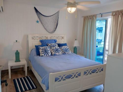 a bedroom with a large bed with blue pillows at Juan Dolio-2da Línea de Playa-Acceso Privado-Piscina-Área de Bbq-Gazebos-Jardines-Balcones-Wifi-Telecable-Netflix-Disney Plus-Campos de Gof-Excursiones-Plazas Comerciales-Minimarket-Restaurantes-Bares-Clubes de Playa in Guayacanes