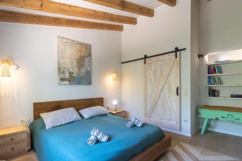 een slaapkamer met een blauw bed en een boekenplank bij Casa Algarrobo in Jávea