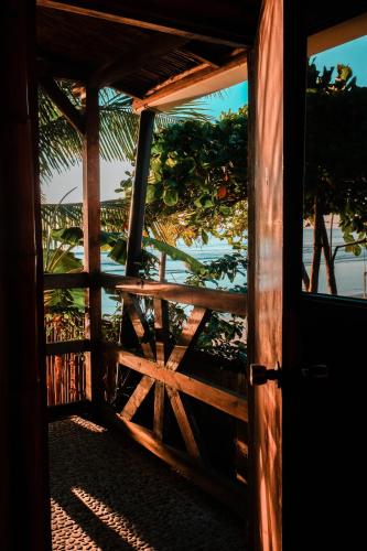 an open door to a wooden gate with a view of the ocean at El Marabu Chill'n Surf in Aposentillo
