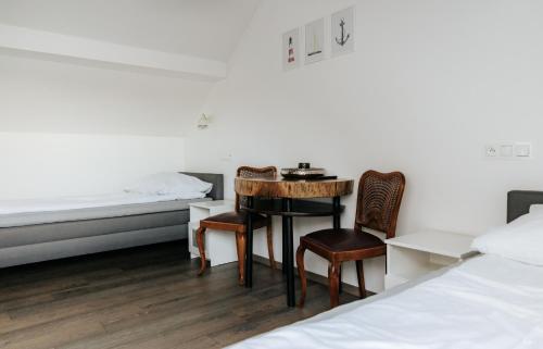 a room with two beds and a table and chairs at Koło Wody in Strzelce