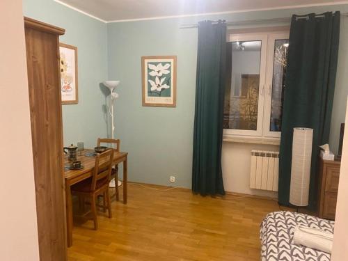 a room with a desk and a table and a window at Na Wspólnej Apartament in Warsaw