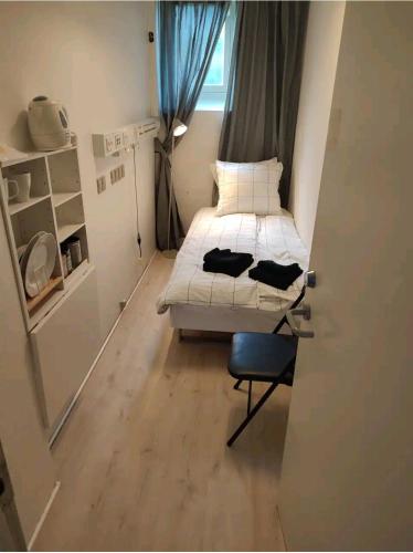 Habitación pequeña con cama y silla en Bjergvænget 16, 2400 København, en Copenhague