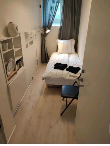 Habitación pequeña con cama y silla en Bjergvænget 16, 2400 København, en Copenhague