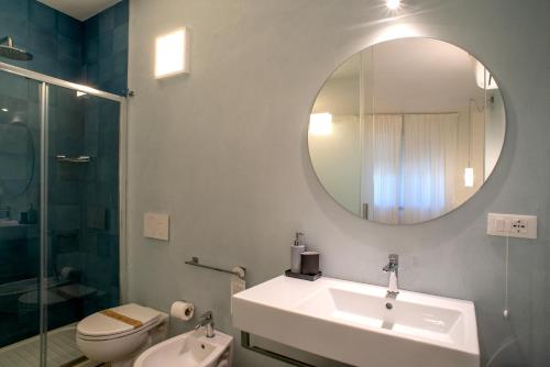 a bathroom with a sink and a toilet and a mirror at B&B Fontanella 32 in Porto SantʼElpidio