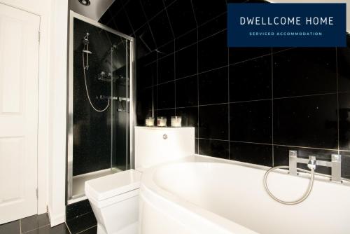 a bathroom with a bath tub and a toilet at Free Drive Parking, Outside LEZ Zone, Garden, Fast WIFI, lovely quiet street, Ideal for long term contractor, corporate etc stays - Dwellcome Home Ltd 5 Double Bedroom 2 and a half Bathroom Aberdeen House - see our site for assurance in Aberdeen
