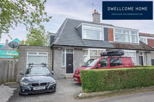 a red car parked in front of a house at Free Drive Parking, Outside LEZ Zone, Garden, Fast WIFI, lovely quiet street, Ideal for long term contractor, corporate etc stays - Dwellcome Home Ltd 5 Double Bedroom 2 and a half Bathroom Aberdeen House - see our site for assurance in Aberdeen