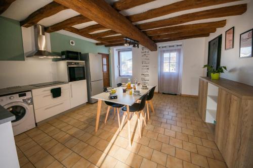 una cucina con tavolo e sedie in una stanza di La maison à Mimine a Le Pin-en-Mauges