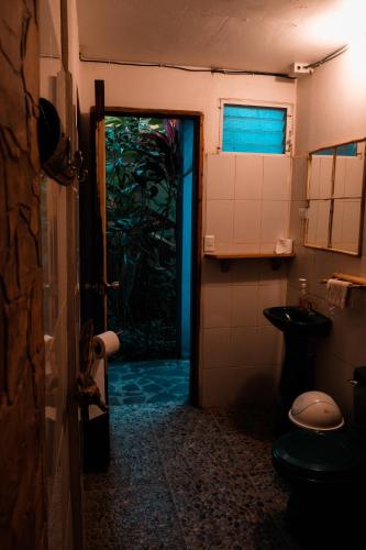 a bathroom with a door open to a bathroom with a toilet at El Marabu Chill'n Surf in Aposentillo