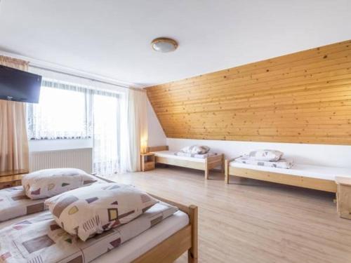 une chambre avec deux lits et une grande fenêtre dans l'établissement Willa Ewka, à Kościelisko