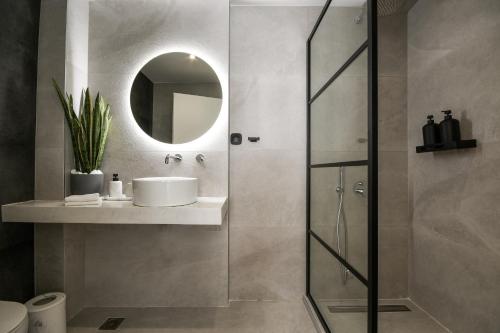 a bathroom with a shower with a sink and a mirror at Luxury Downtown Apartment C1 in Thessaloniki
