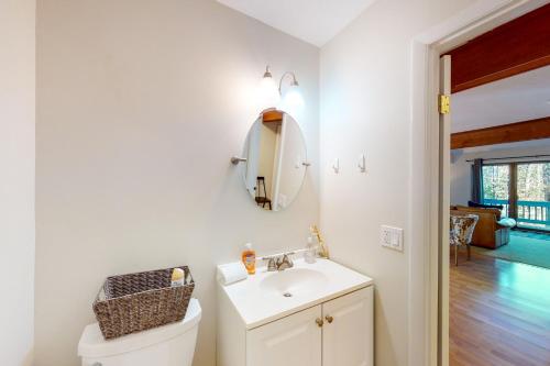een witte badkamer met een wastafel en een spiegel bij Kingswood 12H in White River Junction