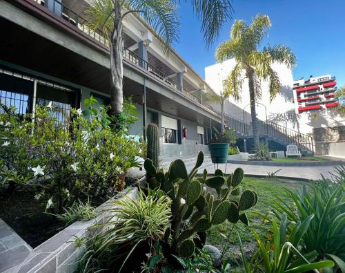 un jardín frente a un edificio con plantas en Posada del Angel en Villa Carlos Paz