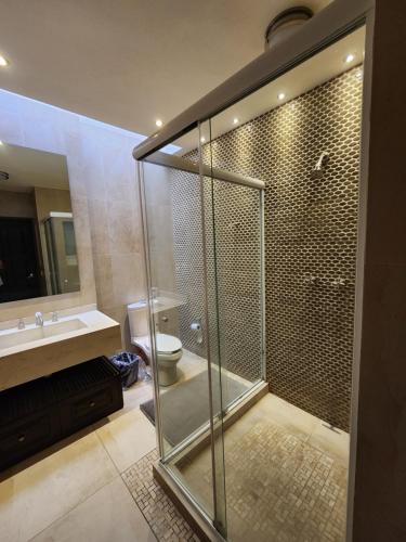 een badkamer met een douche, een toilet en een wastafel bij Casa monarca in Morelia