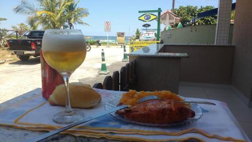 a table with a glass of wine and some food at Felicidade in sea front in Saquarema