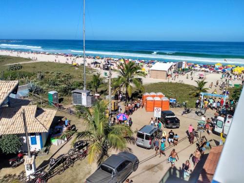 a crowd of people on a beach with the ocean at Felicidade in sea front in Saquarema