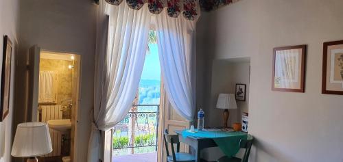Cette chambre dispose d'une porte donnant sur un balcon avec une table. dans l'établissement Soggiorno Dimora Del Grifo, à San Miniato