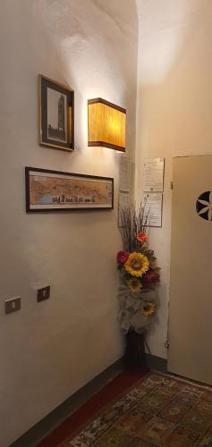 a hallway with a door with a vase of flowers at Soggiorno Dimora Del Grifo in San Miniato