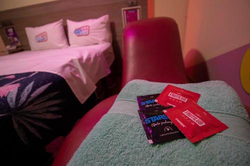 a hotel room with a bed and a book on a chair at Motel ruta slavic in Punta Arenas