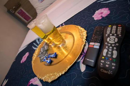 a glass of beer on a coaster next to a remote control at Motel ruta slavic in Punta Arenas