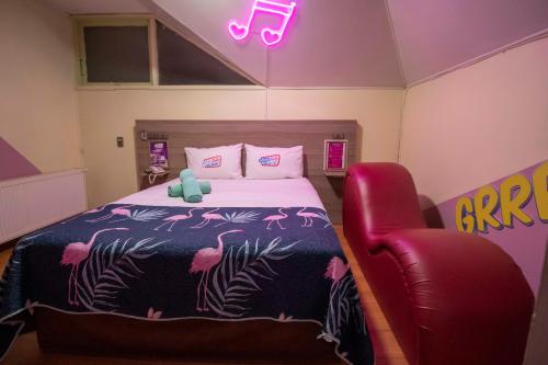 a bedroom with a bed and a red chair at Motel ruta slavic in Punta Arenas