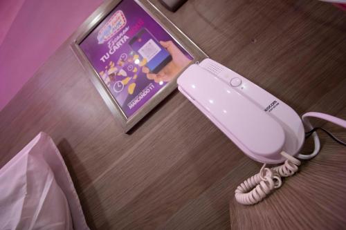 a phone on the floor next to a book at Motel ruta slavic in Punta Arenas