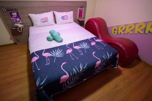 a bedroom with a bed with a pink flamingo bedspread at Motel ruta slavic in Punta Arenas