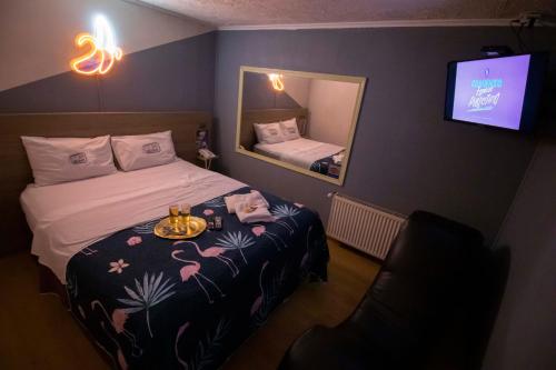 a room with a bed with a mirror and a television at Motel ruta slavic in Punta Arenas