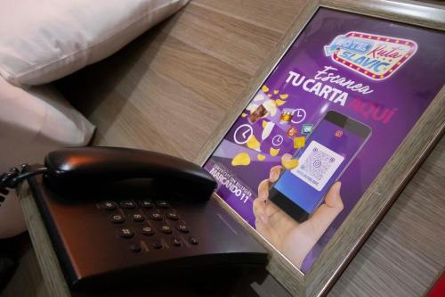 a phone sitting on top of a table next to a book at Motel ruta slavic in Punta Arenas