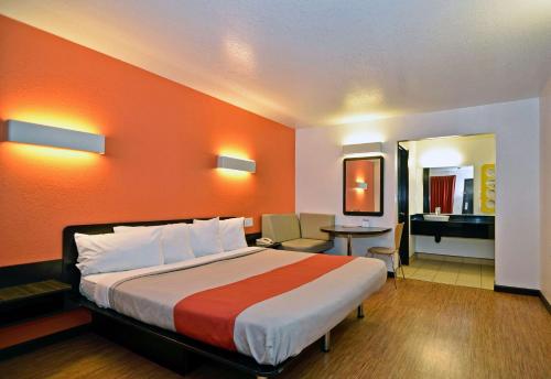 a hotel room with a bed with an orange wall at Motel 6-Fairfield, CA - Napa Valley in Fairfield