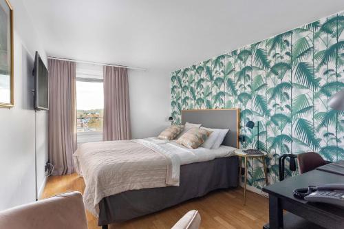 a bedroom with a bed with a green and white wallpaper at Best Western Hotell Hudik in Hudiksvall