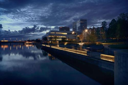 a view of a river at night with a city at U&Me; BW Signature Collection in Umeå