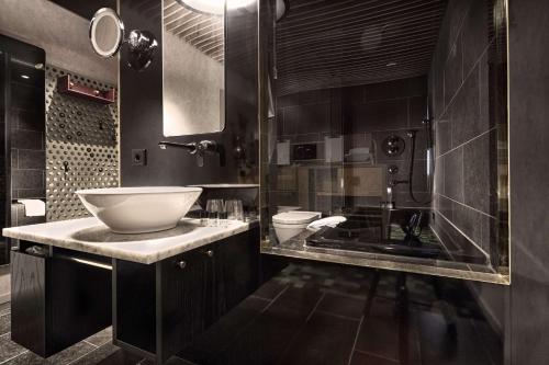 a black bathroom with a sink and a toilet at U&Me; BW Signature Collection in Umeå