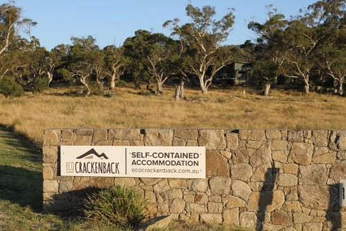 a sign for a self contained association on a stone wall at Ecocrackenback 7 Sustainable chalet close to the slopes in Crackenback