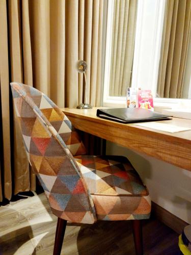 a chair sitting at a desk with a laptop at Best Western Premier Hotel Gulberg Lahore in Lahore
