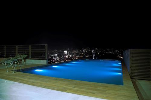 a swimming pool on top of a building at night at Best Western Premier Hotel Gulberg Lahore in Lahore