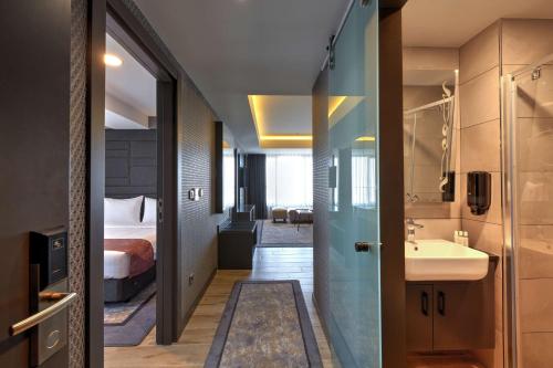 Habitación de hotel con baño y cama en Nova Vista Deluxe & Suites a Member of Radisson Individuals en Eskisehir