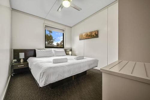 - une chambre avec un grand lit et une fenêtre dans l'établissement Ecocrackenback 7 Sustainable chalet close to the slopes, à Crackenback